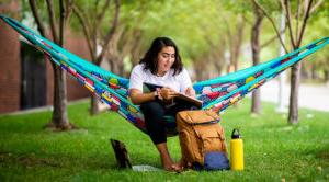 A student studies on a hammock on Auraria Campus.